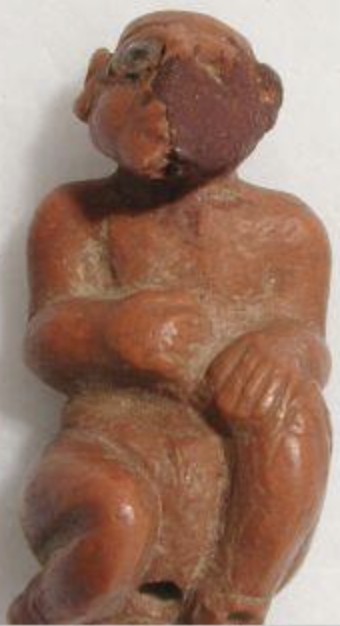 Damaged red limestone seated man with an eye of crystal captive Damaged red limestone seated man with an eye of crystal captive