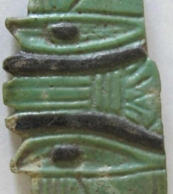 Green and black glaze with a lotus in between double Wedjat