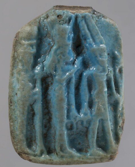 Blue glazed plaque of the Theban triad, top broken Blue glazed plaque of the Theban triad, top broken