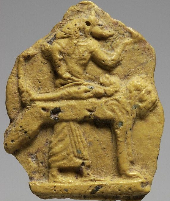 Yellow glass fragmentary inlay of Anubis attending a mummy on its bier